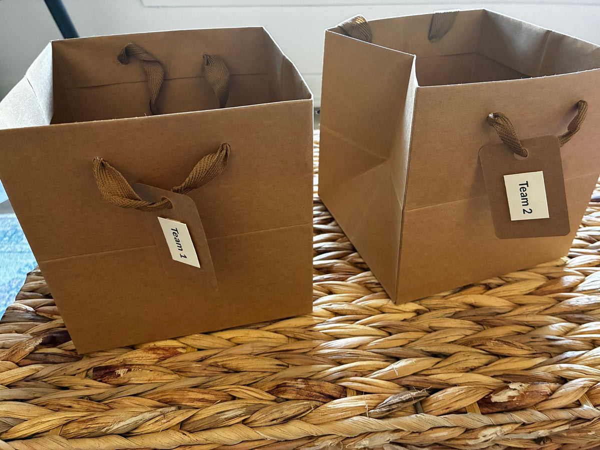 Two brown paper bags labeled Team 1 and Team 2 for Charades Night